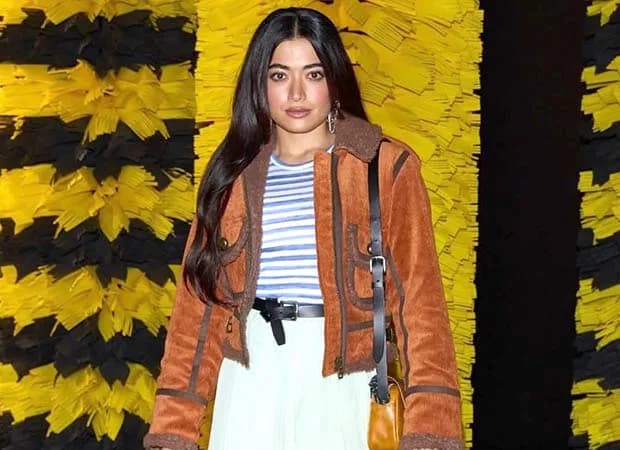 Rashmika Mandanna in a mustard orange corduroy jacket and mint green pleated mini skirt at Milan Fashion Week
