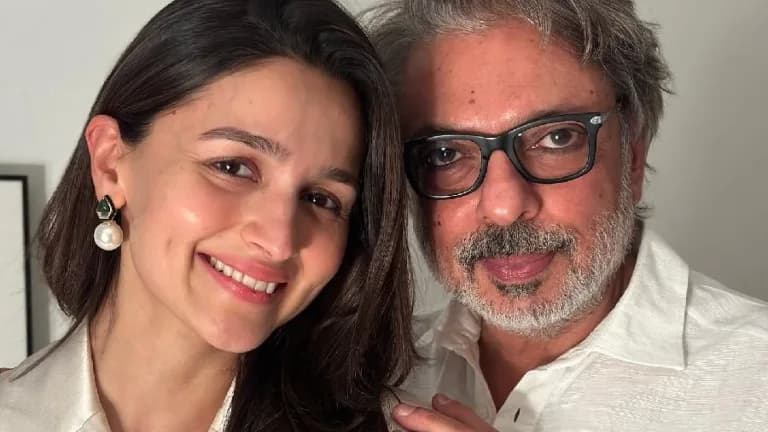 Alia Bhatt and Sanjay Leela Bhansali standing together at a film event, both looking serious and focused.