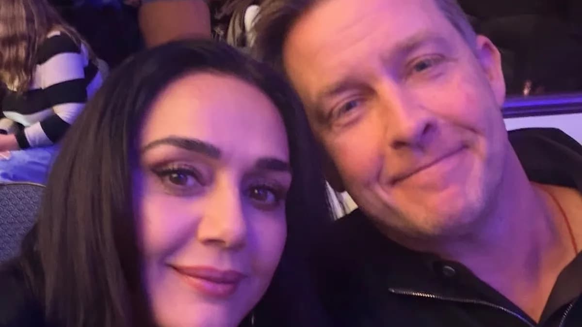 Preity Zinta looking up at a cloudy sky, phone in hand, mid-tweet